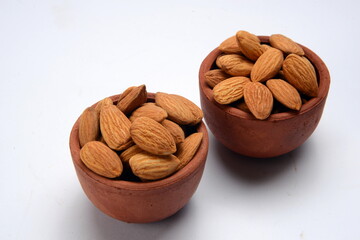 Fresh almonds in the wooden bowl, Organic almonds, almonds border white background, Almond nuts on a dark wooden background. Healthy snacks. Top view. Free space for text.