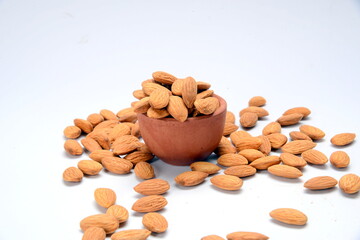 Fresh almonds in the wooden bowl, Organic almonds, almonds border white background, Almond nuts on a dark wooden background. Healthy snacks. Top view. Free space for text.