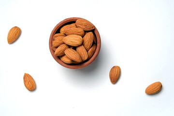 Fresh almonds in the wooden bowl, Organic almonds, almonds border white background, Almond nuts on a dark wooden background. Healthy snacks. Top view. Free space for text.