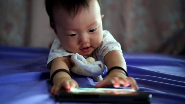 Little baby grab the hp and try to chew. Cute infant boy