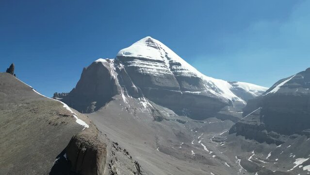 Aerial footage of the sacred Mount Kailash with a snowy peak under the blue sky