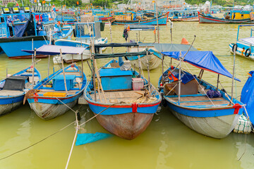 Naklejka na ściany i meble Seaport of fishing vessels in Vietnam. The southern part of Nha Trang city on a cloudy day. 