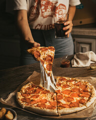 person holding pizza in kitchen