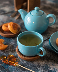 teapot and cup of tea with cookies