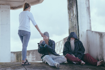  female giving money to poor or homeless people poverty beggar in the city sitting on the streets with a sign for help., homeless poor people and depression concepts.