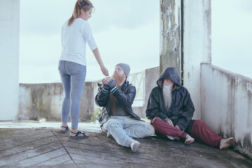  female giving money to poor or homeless people poverty beggar in the city sitting on the streets with a sign for help., homeless poor people and depression concepts.