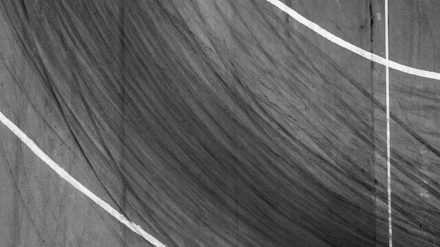 Background with tire marks on road track, Car track asphalt pavement background at the circuit, Abstract asphalt road background with crossing of tires tracks, Black tyre mark on asphalt road. - Powered by Adobe