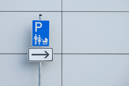 Ein Parkplatzschild für Familien mit Kind und Richtungspfeil