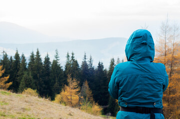 a young pretty girl without a face enjoys a vacation in a hat and jacket against the background of...