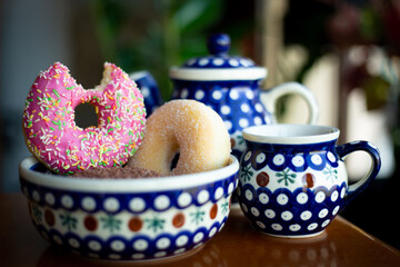 Donuts and beautiful teapot and cup on board
