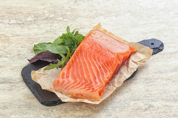 Raw salmon fillet over board