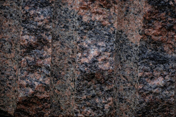 Red granite with dark gray stripes and lines, closeup, background.