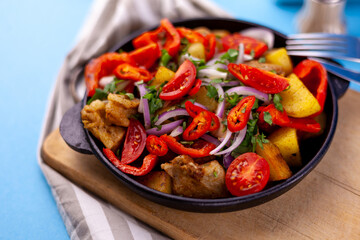 Pork ojakhuri with vegetables. Meat, potatoes, onions, herbs, peppers cooked and served in a skillet. A dish of Georgian cuisine. Meat food, lunch, dinner on the table