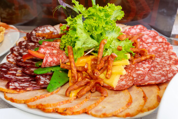 plate with meat sliced decorated salad. Clouse up.