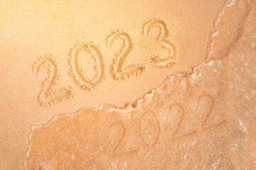 number of the new year written in sand, on tropical beach. Change numbers 2022 to 2023. New year...