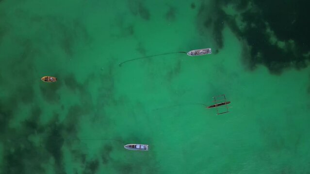 Small boats anchored in shallow waters at Uroa beach Zanzibar Island, Tanzania Africa, Aerial top view rotating shot