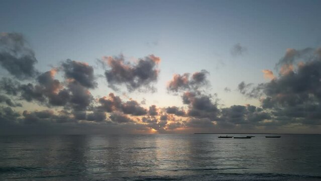 Small fishing boats anchored near Uroa beach coast in Zanzibar Island during sunset, Tanzania Africa, Aerial dolly in shot