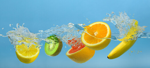 Fototapeta na wymiar Fruits mix splashing into clear water on blue background
