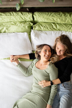 Female same sex couple  affectionately lying together on the bed