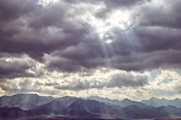 Sunlight shine through clouds over the mountains