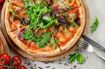 Fresh pizza with meat and vegetables on the concrete background