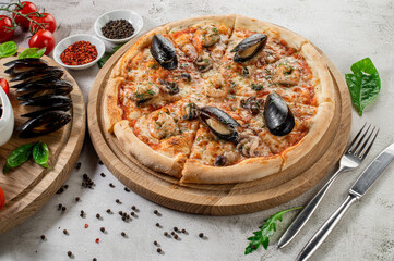 Tasty pizza with a seafood, squids and mussels on the concrete background