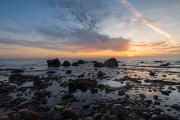 Strand mit großen Steinen am Meer bei Sonnenaufgang.