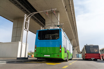Electric bus at a stop is charged by pantograph