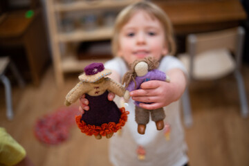 Child holding international felt dolls