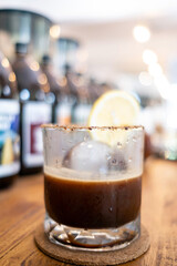 Ice ball in a clear glass of ice americano coffee with warm tone color and bokeh  background of cafe