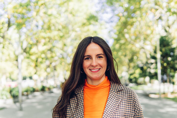 Portrait of a happy woman with a perfect smile looks at the camera on the street