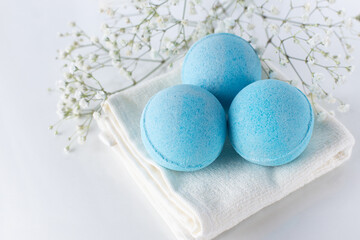 Blue bath bombs on towel on white background. Beauty spa, aroma cosmetic composition..