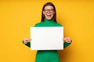 Excited woman office worker holding big white paper banner with empty space for your promo text