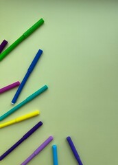 Multicolored felt-tip pens on a light green background