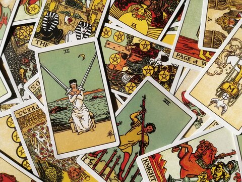 Picture of the Two of Swords tarot card from the original Rider Waite tarot deck with mixed tarot cards in the background