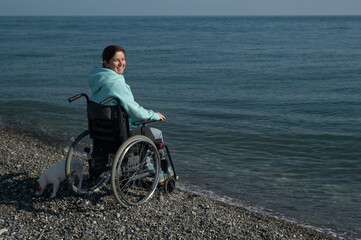 Pacified caucasian woman in a wheelchair on the seashore. 