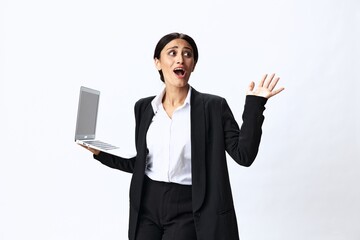 Business woman with laptop in hand in black business suit shows signals gestures and emotions on white background, freelancer job online training