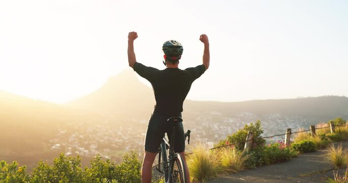 Bike, freedom and motivation with a man cyclist celebration while in nature for fitness or exercise. Mountian, sky and success with a male bicycle rider cheering as a winner on a summit at sunset