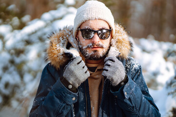 Bearded man smiling at camera in winter park. Season, christmas, travel and people concept.