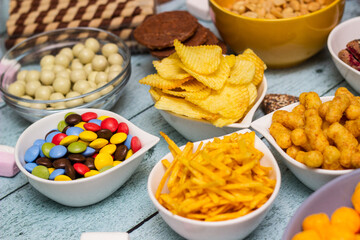 Salty and sweet snacks. Table of salty and sweet snacks. Large group of unhealthy food