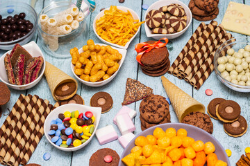 Salty and sweet snacks. Table of salty and sweet snacks. Large group of unhealthy food