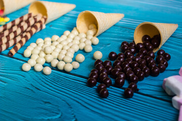 Ice cream cones with colorful candies, cookies, and chocolate balls
