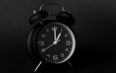 remote image of The black alarm clock is set to 1:00 a.m. on a dark background
