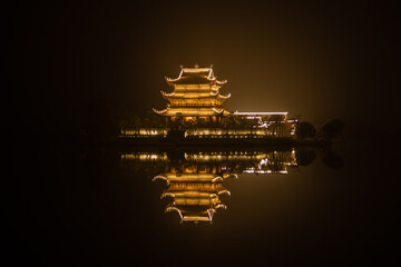 Illuminated Vietnamese temple on the water at night