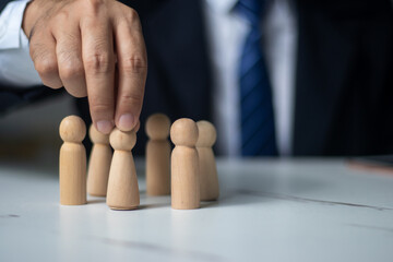 Executives hand in hand with wooden dolls. (organization management concept)