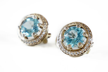 beautiful earring with blue topaz and many white diamonds on white background