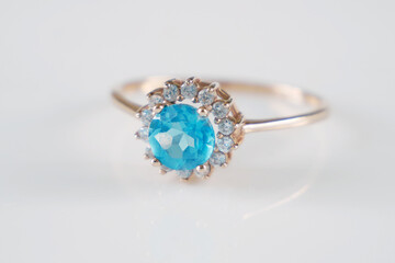 beautiful ring with blue topaz and many white diamonds on white background