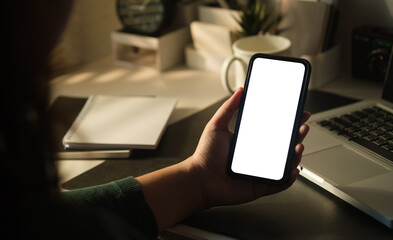 Close up view of woman hand holding mobile phone. White empty screen for your advertise design.