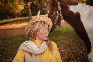 Beautiful picture, autumn nature, woman and horse, concept of love, friendship and care. background. unusual portrait