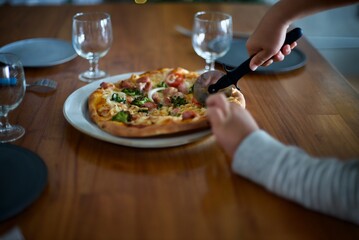 手作りピザをピザカッターで切り分けるところ